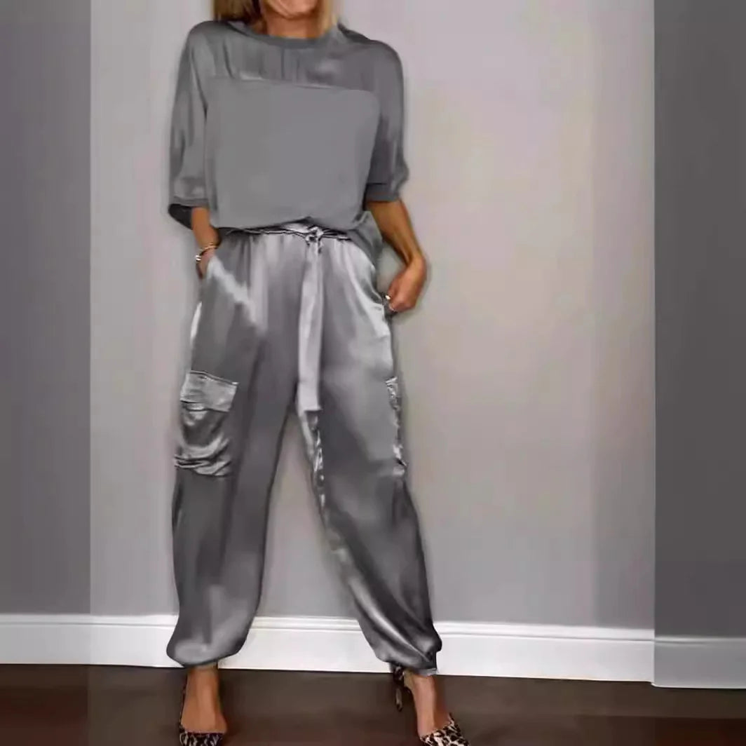 Person wearing a gray outfit with a matching top and pants against a plain background