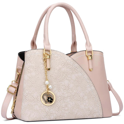 Pink handbag with floral pattern and decorative charm on a white background